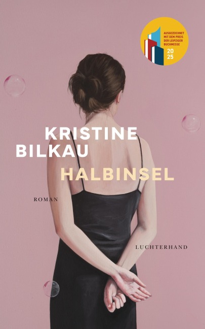 Bild einer jüngeren, dunkelhaarigen Frau, in schwarzem Kleid und verschränkten Armen hinter dem Rücken.